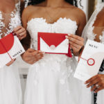 Hochzeitseinladung aufwerten: Rote Hochzeitspapeterie gehalten von modernen Bräuten.